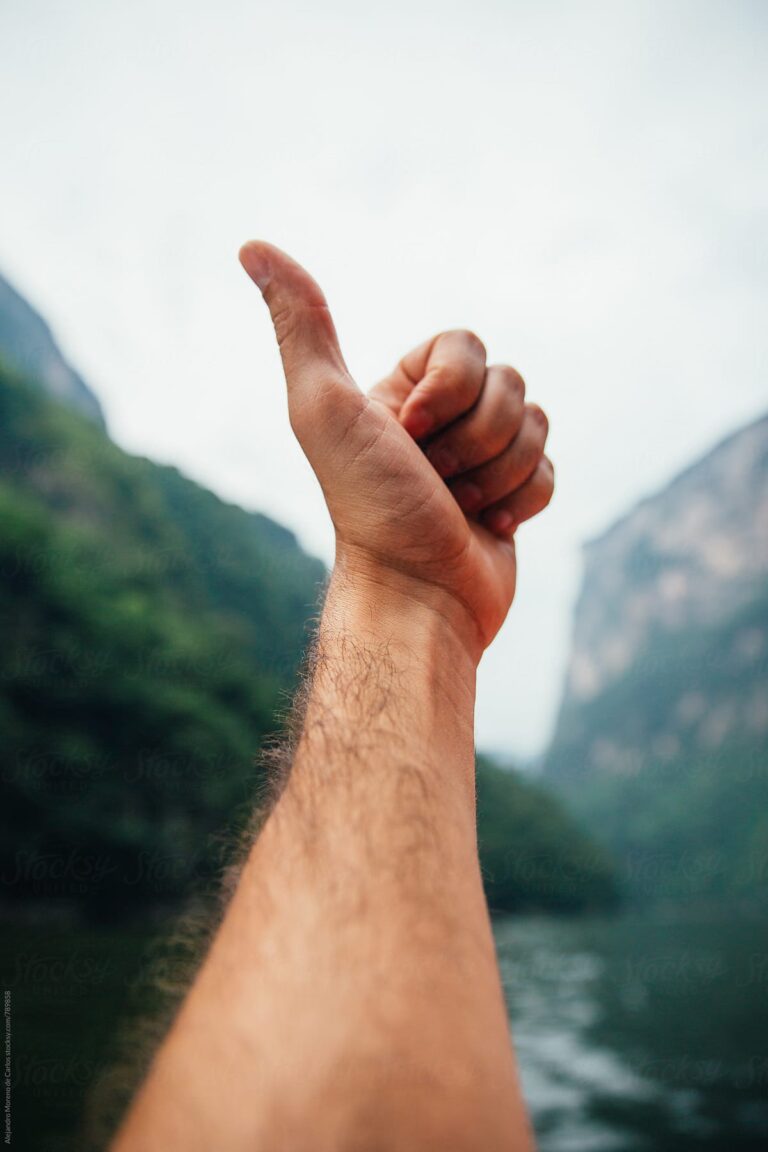 Thumbs Up in Lake with Mountains in the Background