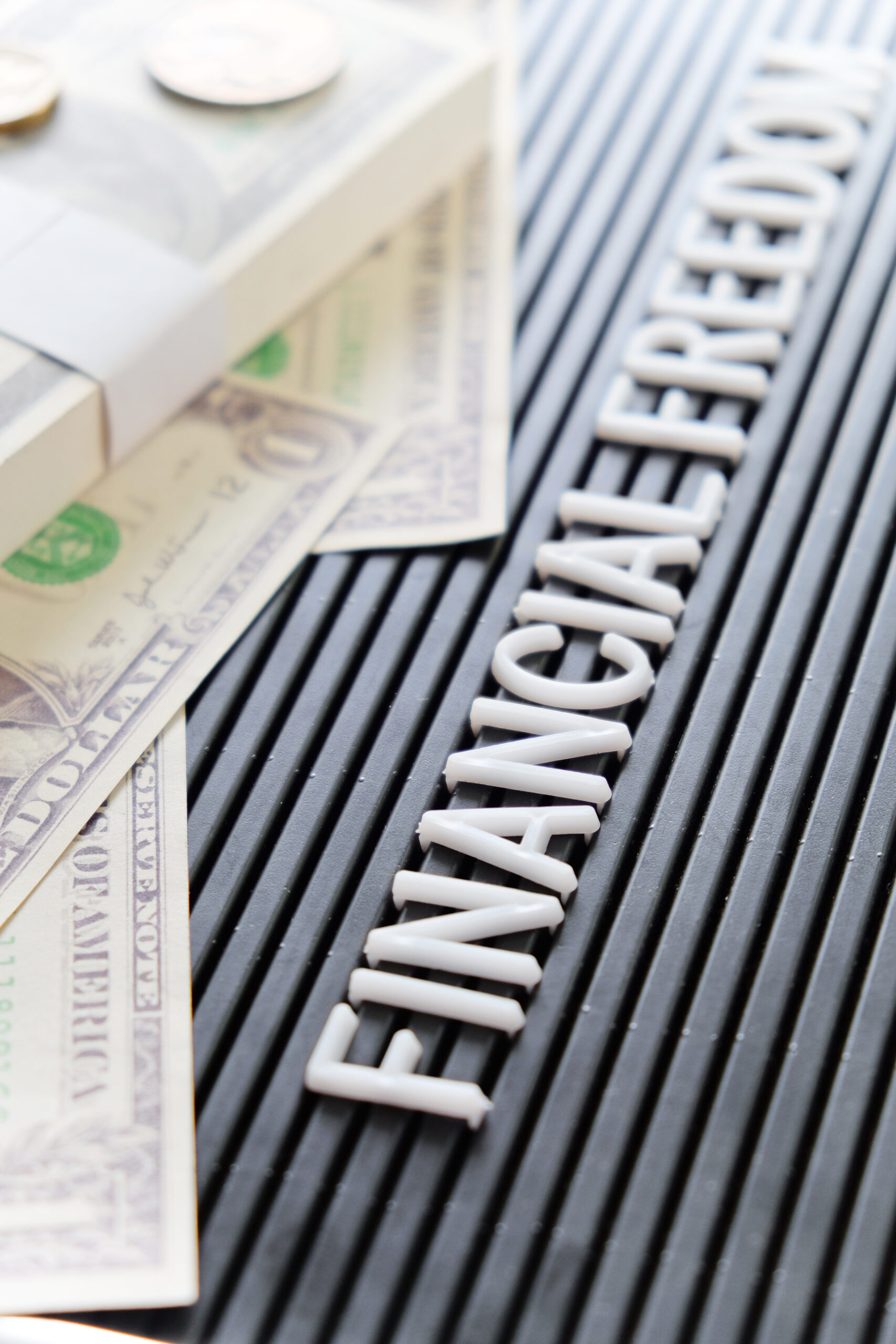 Financial Freedom B&W sign with money stack and coins on top.